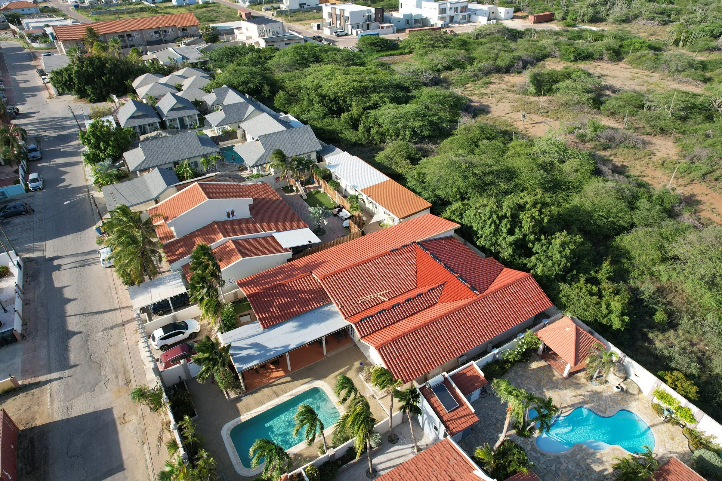 Villas with red tile roofs and pools in a residential neighbourhood