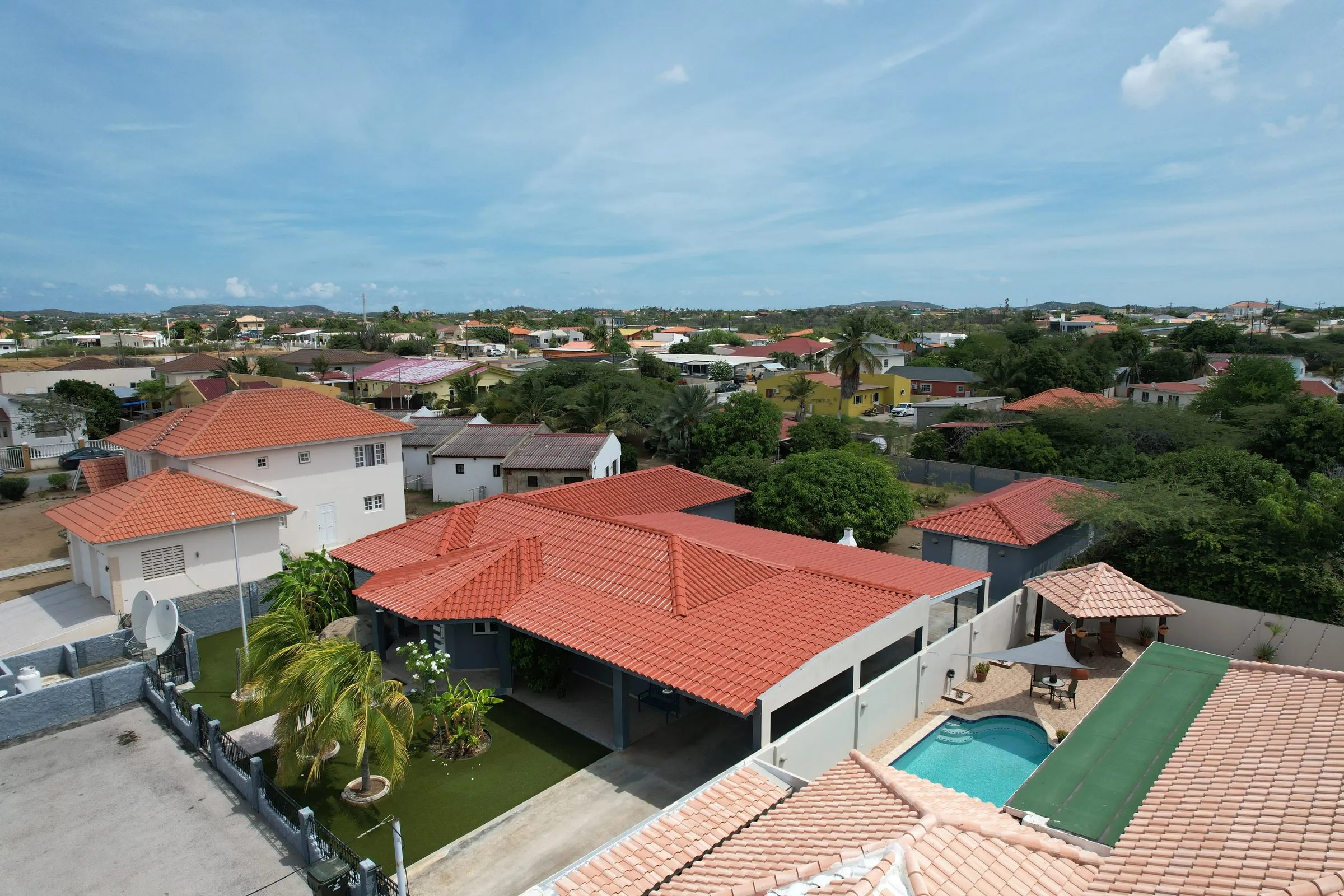 Houses with red tile roofs and a pool